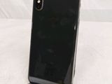 a close up of a black phone on a stand on a white surface
