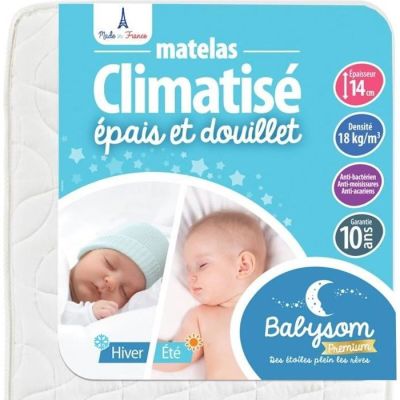 le bébé dort dans le matelas de son lit de bébé, sur lequel est inscrit son prénom