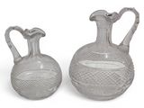 pair of clear glass vases on a white surface with a white background