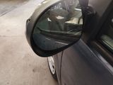 a side view mirror of a car on the side of the road