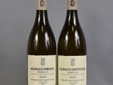 two bottles of wine sitting on top of a table next to each other