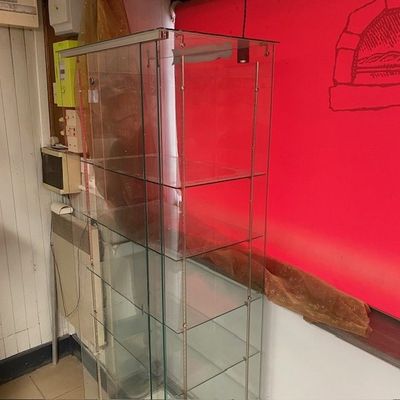 une vitrine en verre dans le coin d'une pièce