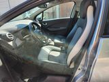 the interior of a car with the door open and the driver ' s seat down