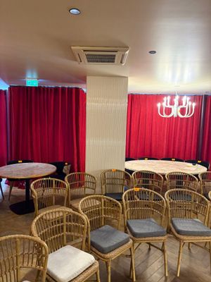 une pièce avec des chaises, des tables et un lustre