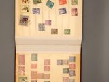 an open book with stamps on it sitting on a table