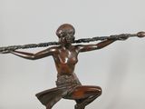bronze statue of a woman holding a sword on a marble base