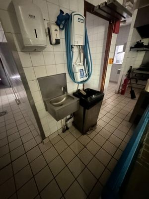 une salle de bains équipée d'un lavabo, de toilettes et d'un sèche-mains