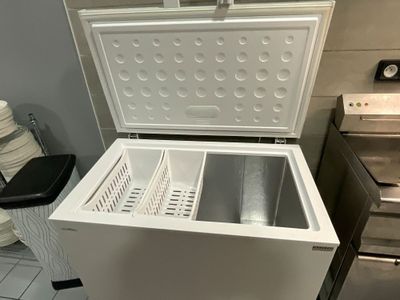 un congélateur coffre blanc posé dans un coin de la cuisine