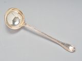 une cuillère en argent ornée d'un miroir, posée sur une table