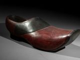 an old wooden shoe with a black and red stripe on the side