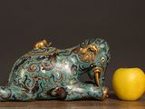 an elephant statue next to an apple on a table
