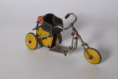 un petit tricycle jouet muni d'un panier à l'arrière