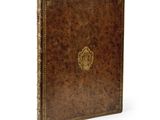 un livre en cuir marron orné d'un emblème doré