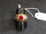 un briquet orné d'une pierre rouge et muni d'une étiquette de prix