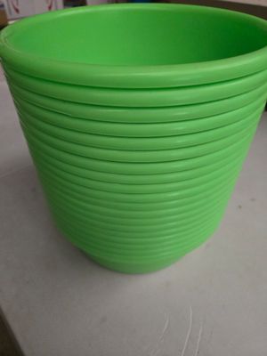 plusieurs bols en plastique verts empilés les uns sur les autres sur un plan de travail