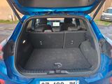 the back of a blue car with its trunk open in a parking lot
