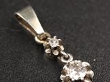 un gros plan d'un pendentif en diamant posé sur une surface noire