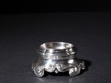 a close up of a silver ring on a black surface