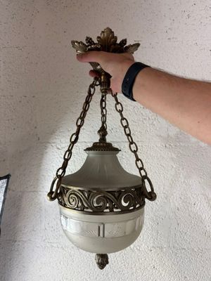 une personne qui tient une lampe suspendue au plafond