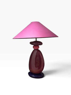 purple glass table lamp with a pink shade on a black base