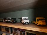 de nombreux camions miniatures posés sur une étagère dans une pièce