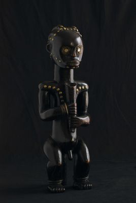 une statue noire et dorée représentant un homme tenant une guitare