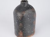 a black vase that is sitting on a white surface