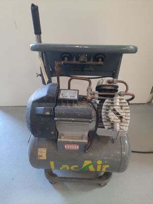 a small air compressor sitting on the floor in a room