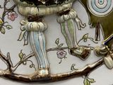 a decorative plate with a bird on it on a table
