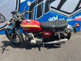 une moto rouge garée devant un mur recouvert de graffitis