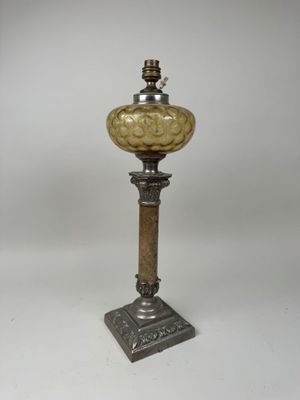une lampe à l'ancienne avec un pied en métal et un abat-jour en verre