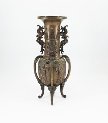 a bronze vase on a stand on a white background