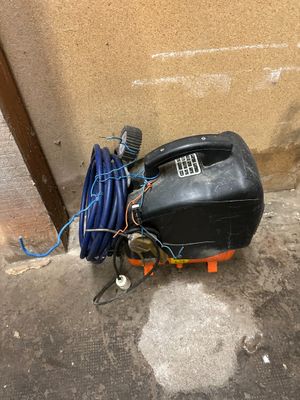 a black tank with a hose and a blue hose on the ground