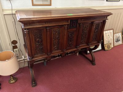 a large wooden cabinet with a lamp on top of it