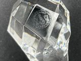 a clear glass object on a table with a black background