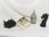 three figurines sitting on a white cloth