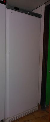 a white refrigerator in the corner of a room