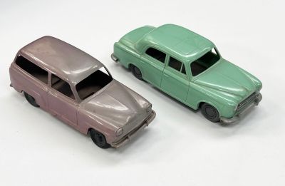 deux voitures jouets assises l'une à côté de l'autre sur une surface blanche