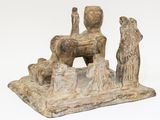 statue of a man sitting on a rock with a dog in front of him