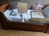 un lit sur lequel est posée une boîte, dans une pièce