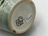 a close up of a vase on a white surface