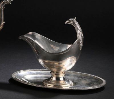 une assiette en argent sur laquelle repose une soucoupe en argent