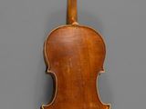 an old violin with a wooden back and bow on a gray background