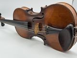 an old violin sitting on top of a white table next to a white wall