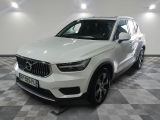 Le SUV Volvo blanc est garé dans une grande pièce.