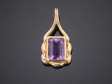 a gold pendant with an amethorate stone in the center