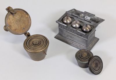 une petite boîte en métal munie d'un couvercle et contenant quelques objets métalliques