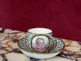 une tasse et une soucoupe sur lesquelles est représentée une femme