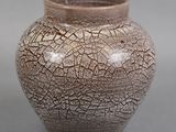 un vase marron dont la surface est craquelée