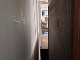 a narrow hallway with a door leading to a kitchen